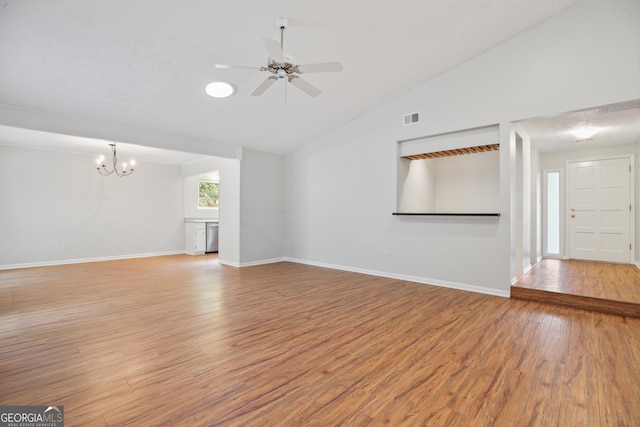 unfurnished living room featuring a chandelier, light wood-style floors, ceiling fan, lofted ceiling, and baseboards