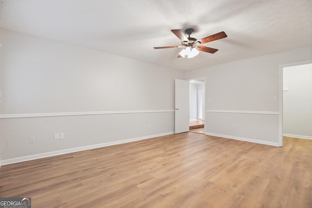 empty room with ceiling fan, baseboards, and light wood-style floors
