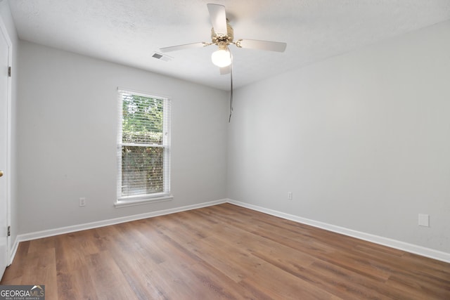 unfurnished room featuring wood finished floors, ceiling fan, and baseboards