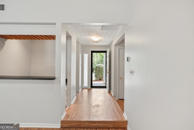 doorway to outside featuring wood finished floors and baseboards