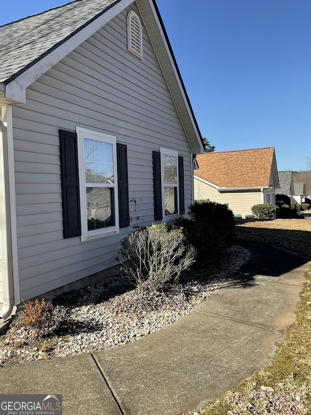 view of property exterior with roof with shingles