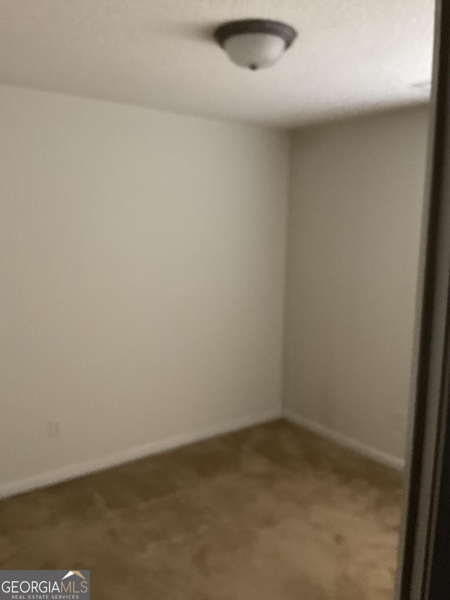 unfurnished room with baseboards and carpet flooring