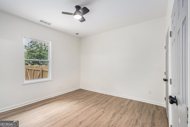 unfurnished room featuring light wood-style floors, baseboards, ceiling fan, and visible vents