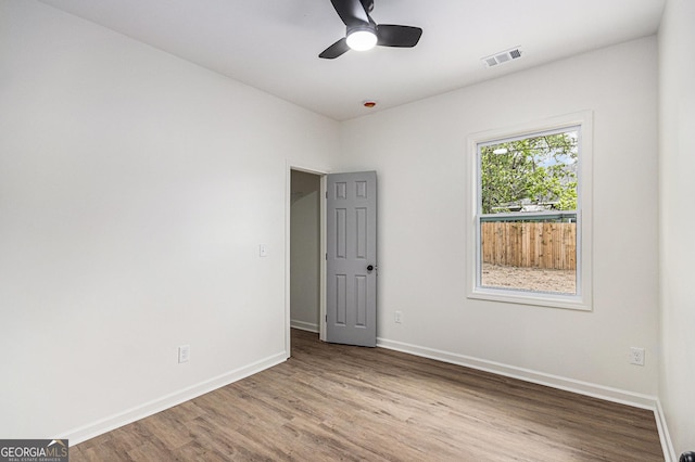spare room with visible vents, baseboards, and wood finished floors