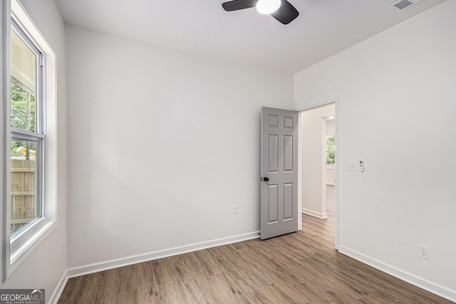 spare room with baseboards, a ceiling fan, and wood finished floors