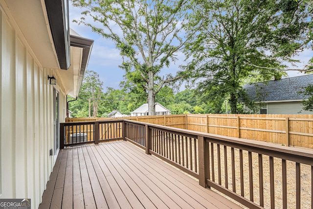wooden deck with a fenced backyard
