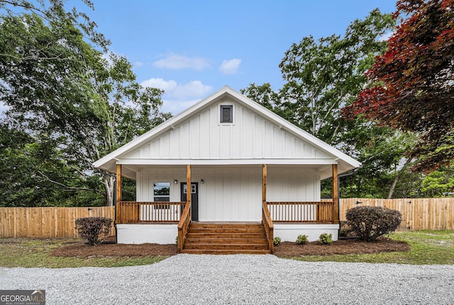 bungalow featuring a porch and fence