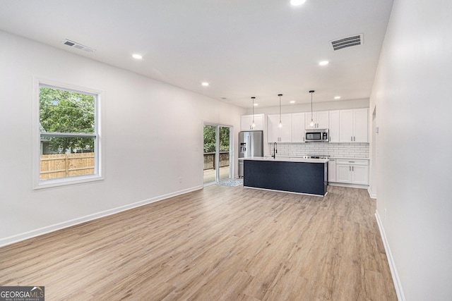 kitchen with stainless steel appliances, visible vents, and plenty of natural light