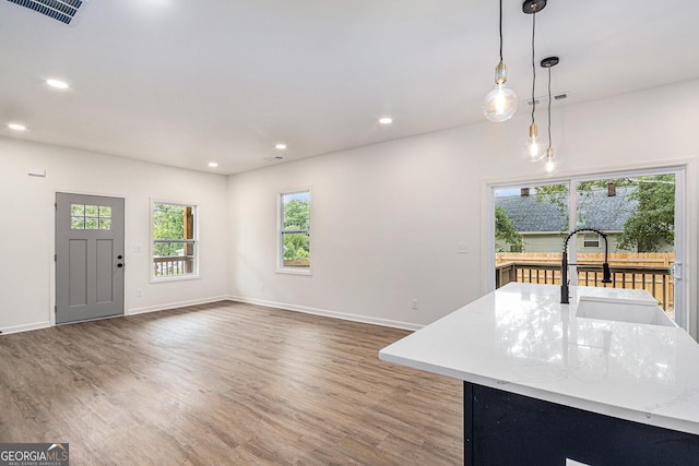 interior space with a sink, recessed lighting, wood finished floors, and visible vents