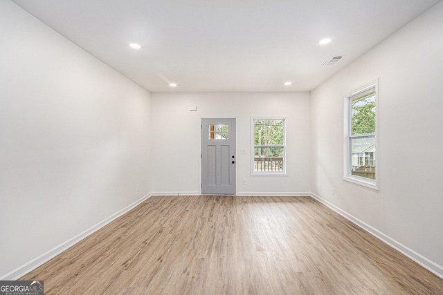 spare room with baseboards, recessed lighting, light wood-style flooring, and visible vents