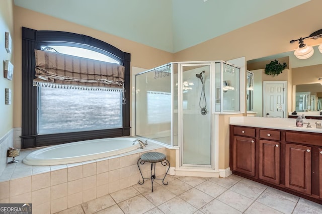 full bathroom with a stall shower, a bath, tile patterned flooring, vaulted ceiling, and vanity