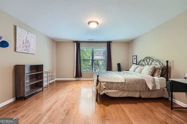 bedroom with baseboards and light wood-style flooring