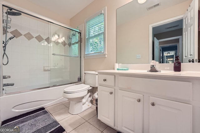 bathroom featuring toilet, enclosed tub / shower combo, tile patterned floors, visible vents, and vanity