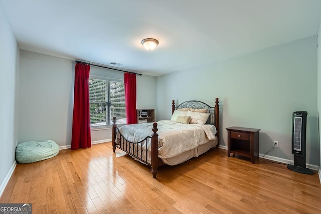bedroom with visible vents, light wood finished floors, and baseboards