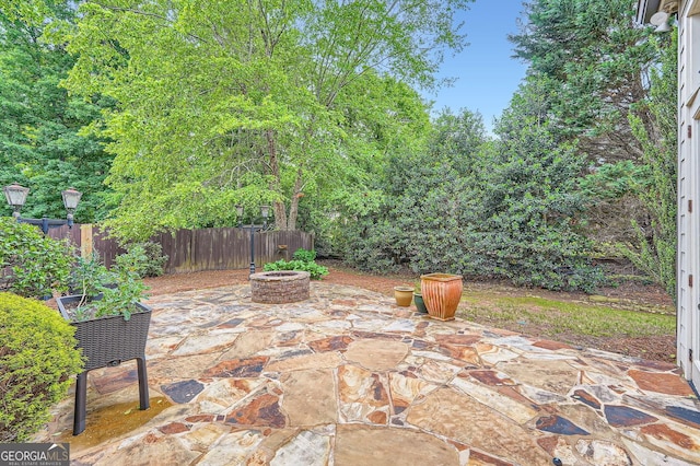 view of patio featuring a fire pit and fence