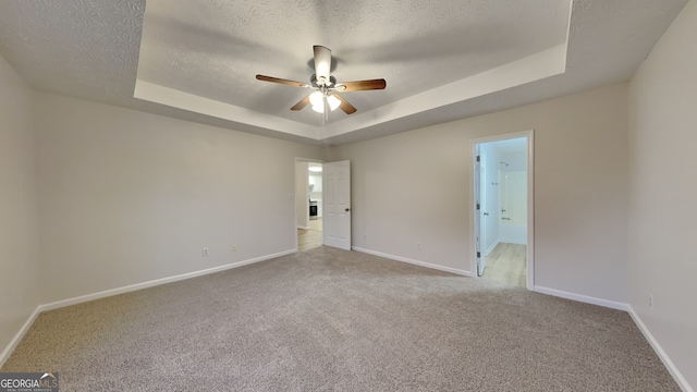 943 Colvin Dr, Locust Grove, GA 30248 - spare room featuring carpet flooring, a ceiling fan, a tray ceiling, and baseboards