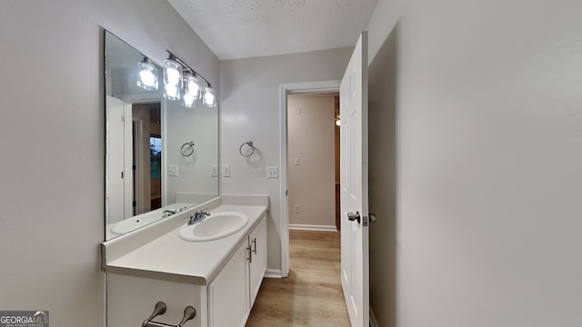 943 Colvin Dr, Locust Grove, GA 30248 - bathroom with vanity, baseboards, a textured ceiling, and wood finished floors