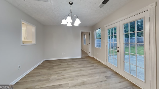 943 Colvin Dr, Locust Grove, GA 30248 - unfurnished dining area featuring french doors, light wood-style floors, baseboards, and a notable chandelier