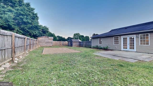 943 Colvin Dr, Locust Grove, GA 30248 - view of yard with a storage shed, a fenced backyard, a patio area, french doors, and an outdoor structure