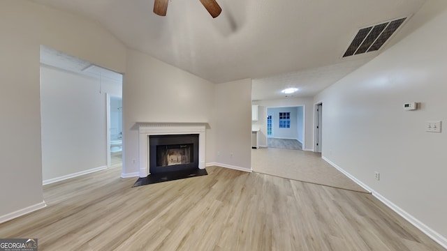 943 Colvin Dr, Locust Grove, GA 30248 - unfurnished living room featuring visible vents, a fireplace with flush hearth, wood finished floors, baseboards, and a ceiling fan