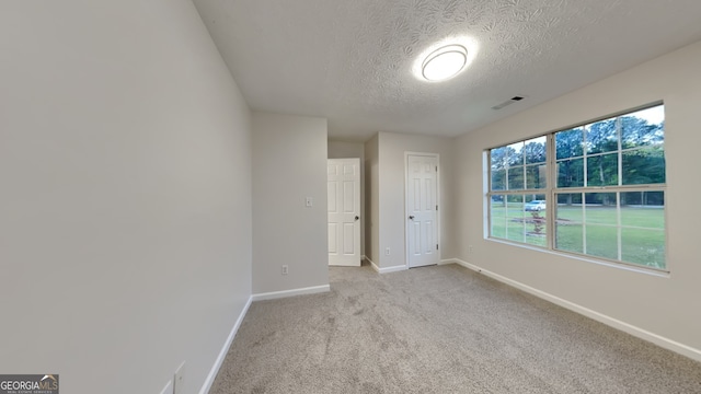 943 Colvin Dr, Locust Grove, GA 30248 - empty room featuring baseboards, a textured ceiling, visible vents, and light carpet