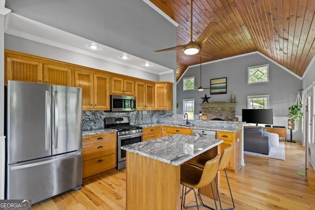 kitchen featuring appliances with stainless steel finishes, a sink, a fireplace, a peninsula, and wooden ceiling