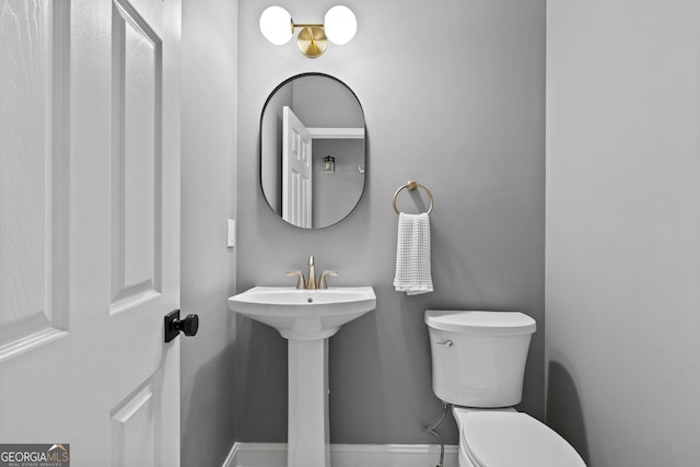 half bathroom featuring toilet and baseboards