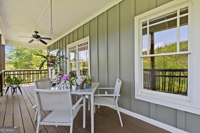 wooden terrace with ceiling fan and outdoor dining area