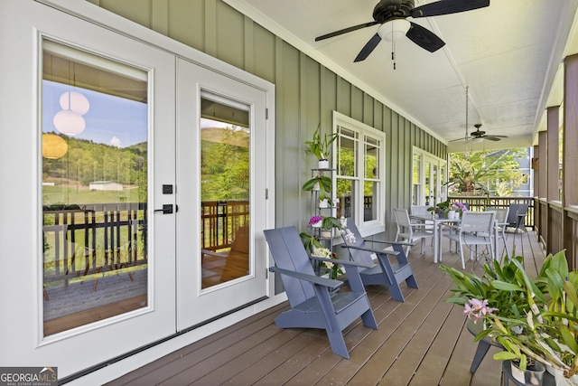 wooden deck featuring a ceiling fan, french doors, and outdoor dining space