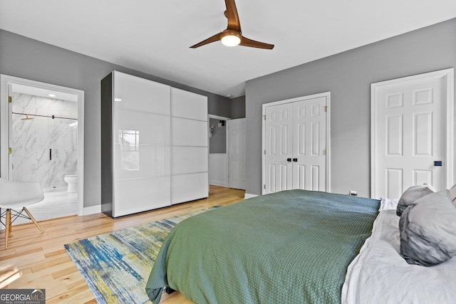 bedroom with a closet, a ceiling fan, ensuite bath, and wood finished floors