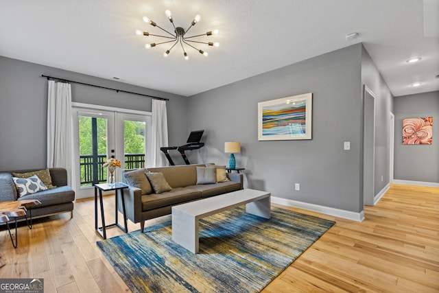 living area featuring baseboards, a notable chandelier, french doors, and light wood-style flooring