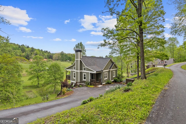 exterior space featuring driveway and a chimney