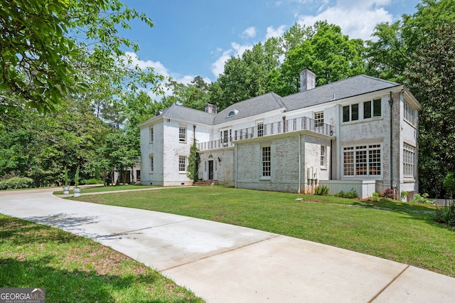 1464 Twin Pines Dr, Macon, GA 31211 - view of front of home with a chimney, a front yard, and a balcony