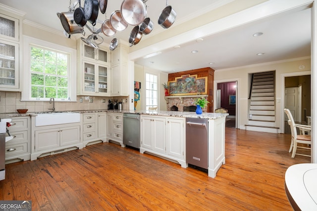 1464 Twin Pines Dr, Macon, GA 31211 - kitchen featuring stainless steel dishwasher, crown molding, a peninsula, a sink, and light wood-style flooring