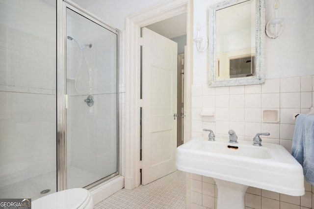 1464 Twin Pines Dr, Macon, GA 31211 - bathroom with tile walls, a shower stall, a sink, tile patterned floors, and toilet