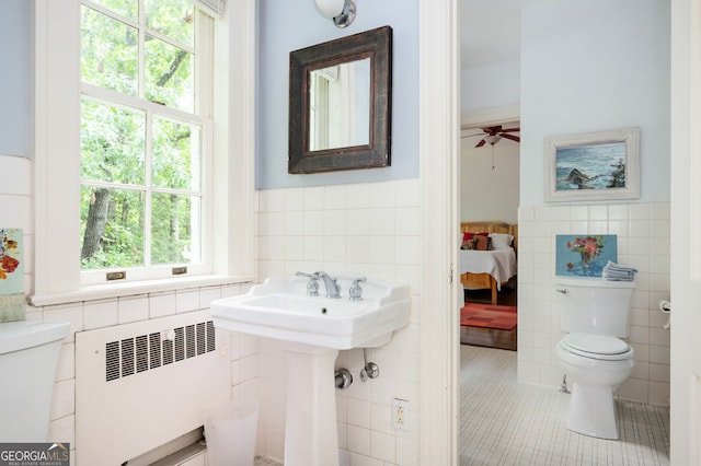 1464 Twin Pines Dr, Macon, GA 31211 - ensuite bathroom with tile patterned flooring, radiator, toilet, tile walls, and a wainscoted wall