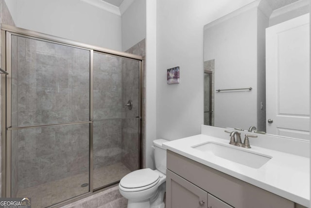 bathroom featuring vanity, toilet, crown molding, and a stall shower