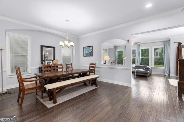 dining area with arched walkways, a chandelier, ornamental molding, baseboards, and dark wood-style floors