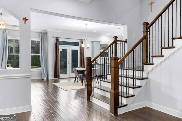 staircase with crown molding, ceiling fan, french doors, hardwood / wood-style floors, and baseboards