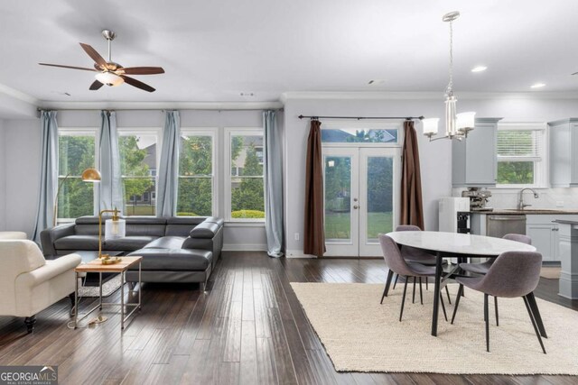 interior space featuring ornamental molding, french doors, ceiling fan with notable chandelier, and dark wood-type flooring
