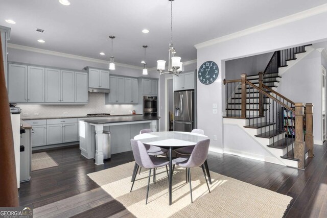 dining room with crown molding, dark wood finished floors, and stairway