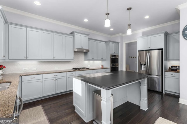kitchen featuring appliances with stainless steel finishes, decorative backsplash, under cabinet range hood, and dark wood-type flooring