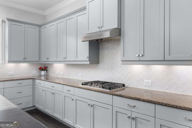 kitchen with stainless steel gas stovetop, tasteful backsplash, stone counters, and under cabinet range hood