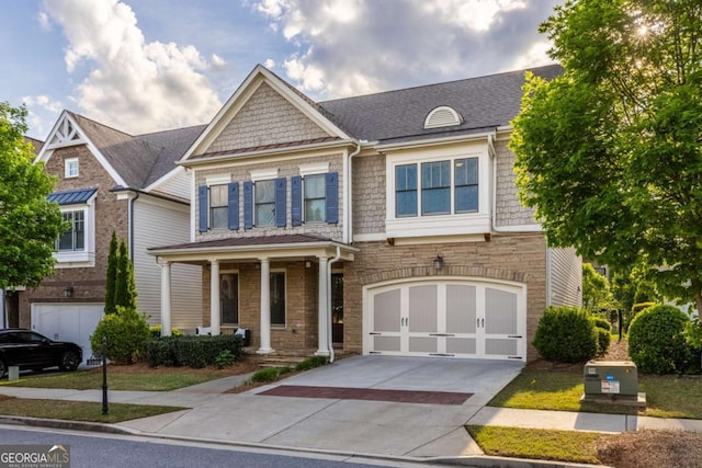 craftsman-style home featuring a garage, stone siding, roof with shingles, concrete driveway, and a porch