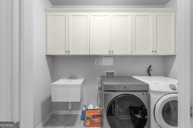 laundry area featuring a sink, separate washer and dryer, baseboards, and cabinet space
