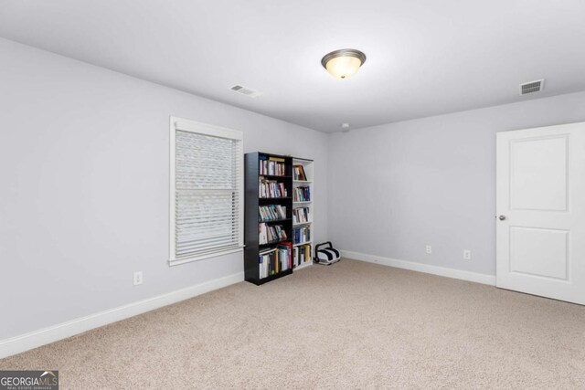 spare room with visible vents, baseboards, and carpet floors