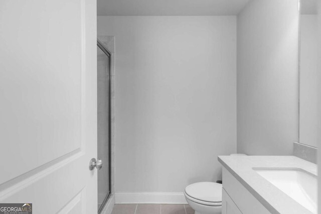 bathroom with tile patterned flooring, a stall shower, toilet, and vanity