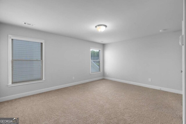 carpeted empty room with baseboards and visible vents