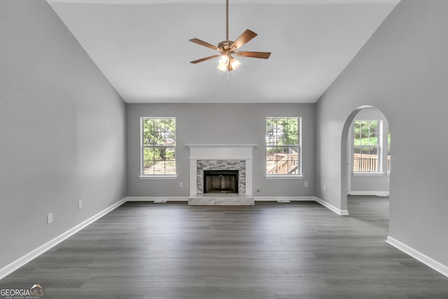 5452 Sweetsprings Dr SW, Powder Springs, GA 30127 - unfurnished living room with ceiling fan, dark wood finished floors, a stone fireplace, baseboards, and lofted ceiling