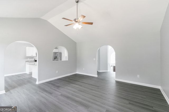 5452 Sweetsprings Dr SW, Powder Springs, GA 30127 - unfurnished living room with ceiling fan, arched walkways, baseboards, high vaulted ceiling, and dark wood-style floors